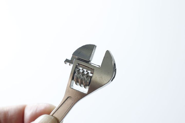 指でモンキーレンチのキーホルダーの調整部分を回す