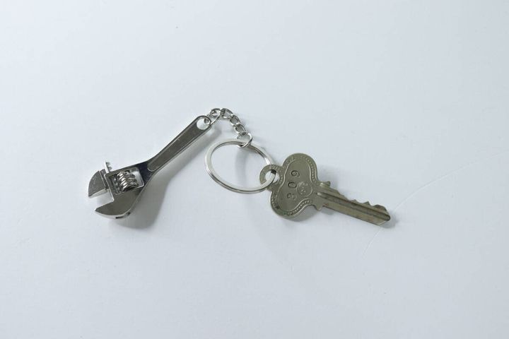 モンキーレンチのキーホルダーと鍵が並べて置かれている