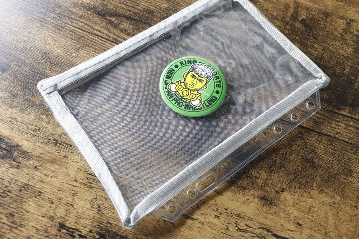 メッシュポーチリフィルの中に緑色の缶バッジが一つ入っている様子