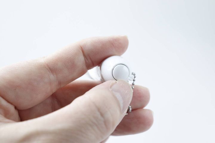 人の指がミニペンライトキーホルダーのスイッチを押している様子
