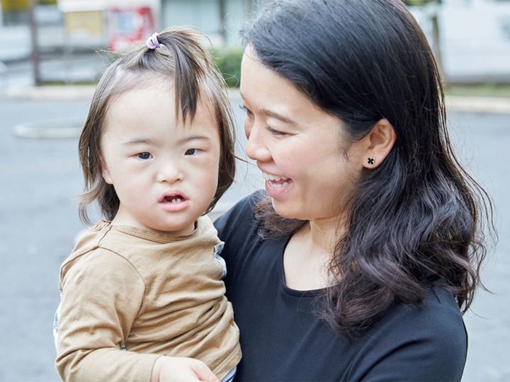 ダウン症のこうくんを抱っこする坂井佳恵さん