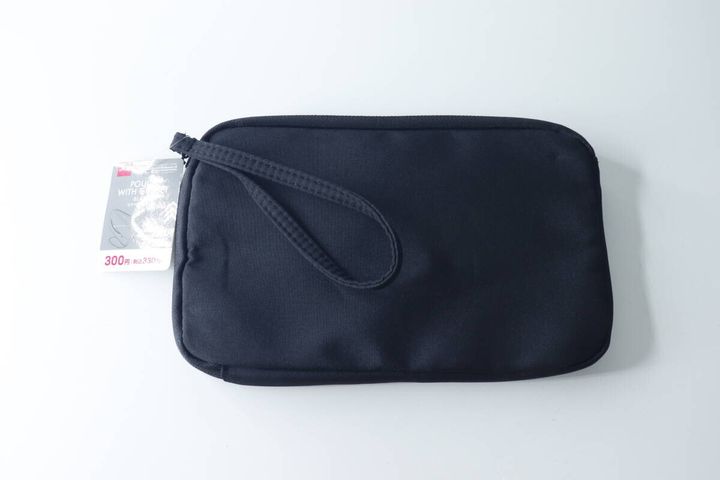黒いマチ付きポーチが白い背景に置かれている様子