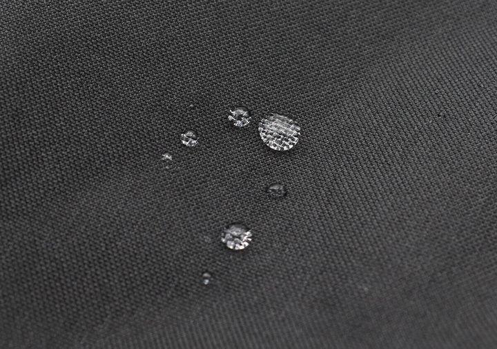 黒い生地に水滴が丸く乗っている撥水加工の様子