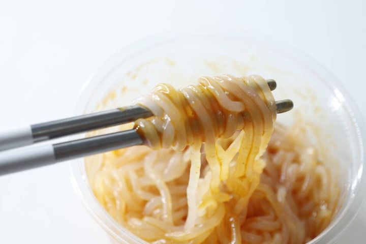 箸で持ち上げられた麻辣湯こんにゃくヌードルのアップ
