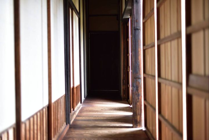 木の床と障子が続く、古い家の細い廊下