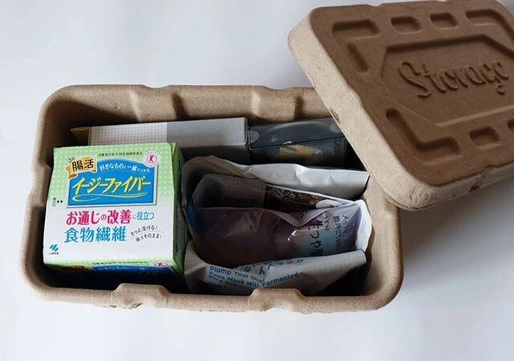蓋が開いた茶色い古紙製ボックスにサプリメントやパックが収納されている