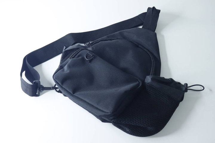 白い背景に置かれた黒いクロスボディバッグの全体像