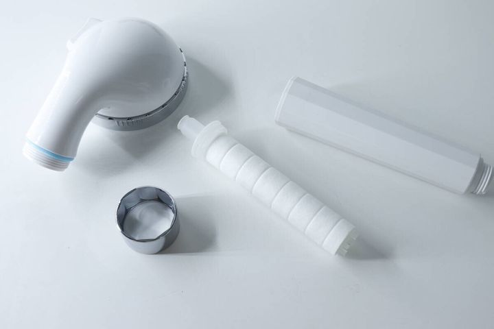 分解されたシャワーヘッドと内部の白い浄水フィルター