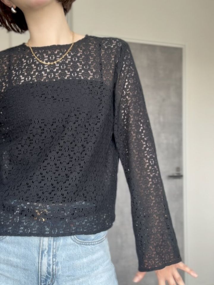 黒いレースブラウスとデニムを着用した女性の胸元
