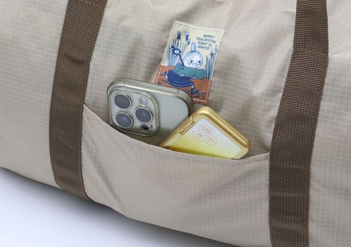 ボストンバッグのフロントポケットにスマホと小物が入っている様子