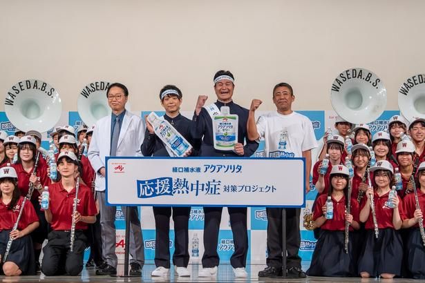 早稲田実業学校高等部吹奏楽部のメンバーと記念撮影に応じた、谷口英喜先生、ティモンディの前田裕太さんと高岸宏行さん、山本忠雄グループ長(写真左から)
