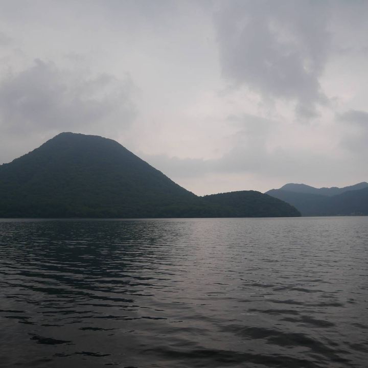 湖の向こうに山並みが広がる、静かな水辺の風景