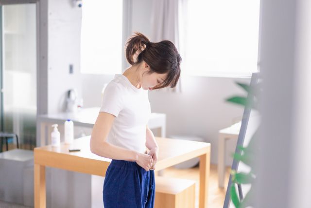 ウエストを見る女性