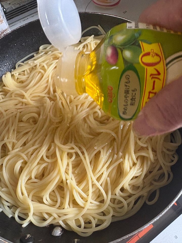 塩を入れて茹でたパスタにオリーブオイルをグルグルとかけます。