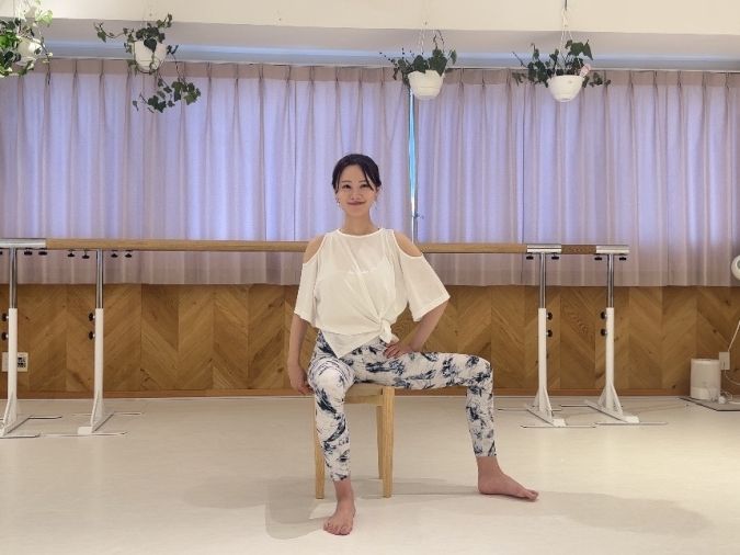 椅子に浅く座り、片脚を横へ開く。