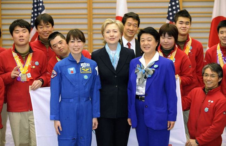 宇宙飛行士の向井千秋さん（中央右）、山崎直子さん（中央左）やスペシャルオリンピックスの選手らと記念写真に納まるクリントン米国務長官＝2009年2月16日夜、羽田空港