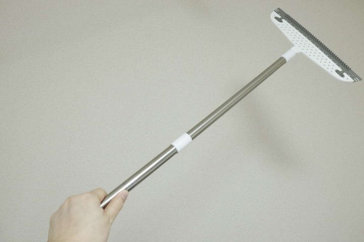 手で持ったキャンドゥのワイパーほうき全体。柄はシルバー。