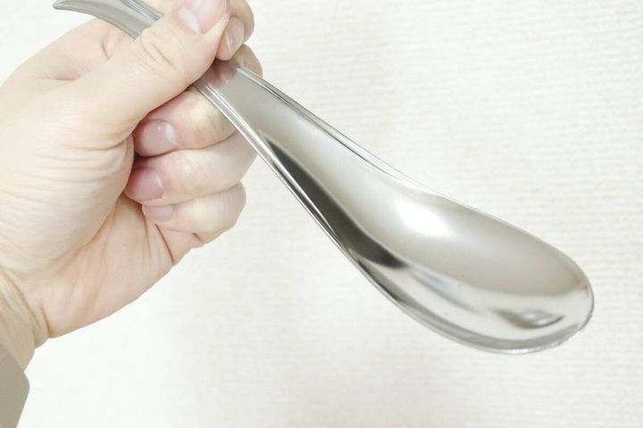 女性の手で持たれたステンレス製レンゲスプーン