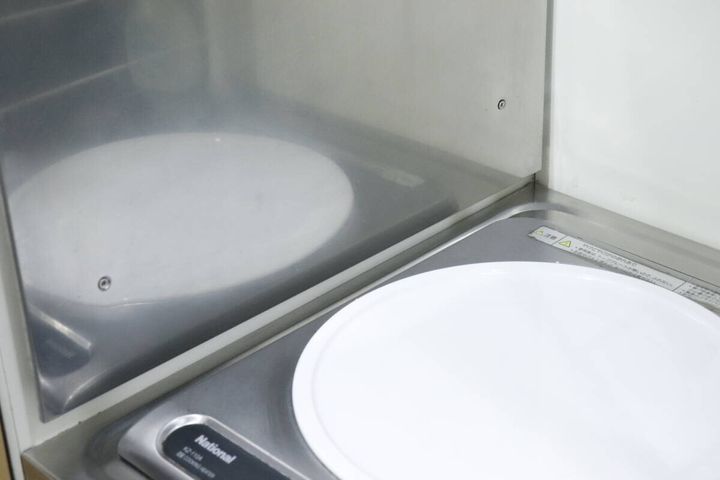 掃除後、ピカピカになったキッチンのステンレス壁面とコンロ