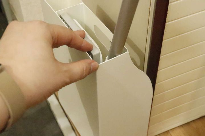 白い収納ボックスから掃除用具を取り出す女性の手元
