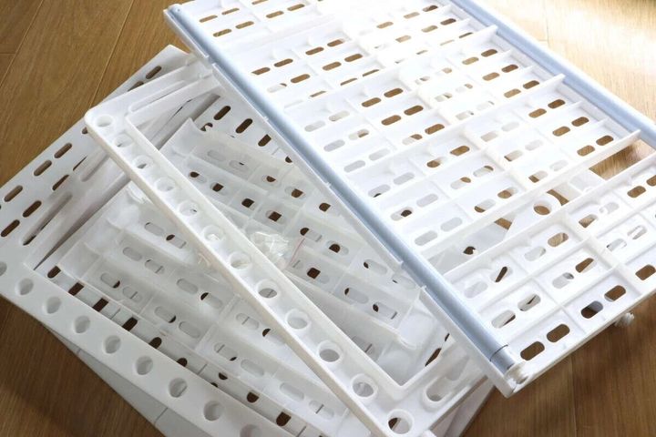 白いプラスチック製のシンク下すきま収納ラックの部品が積み重ねられている