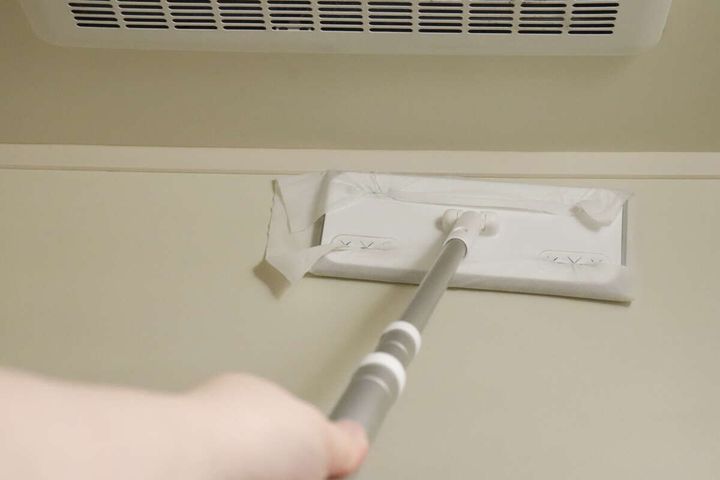 ワイパーにセットしたシートで浴室の壁を掃除している様子
