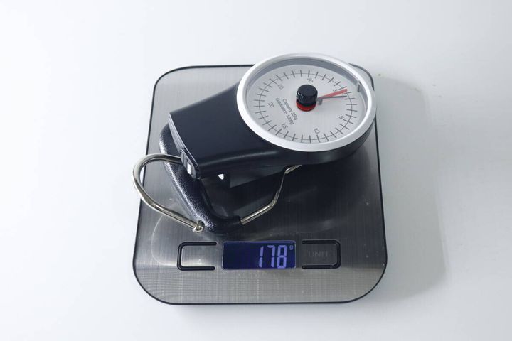 デジタルスケールの上に置かれたスーツケース用計り。スケールには178gと表示。