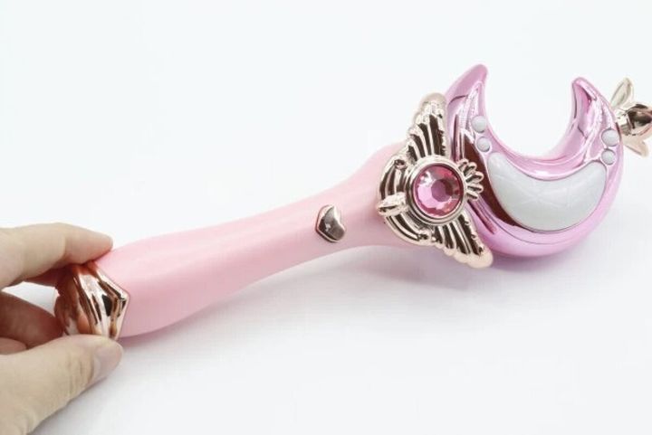 ピンク色の月型光るステッキを右手が持っている様子