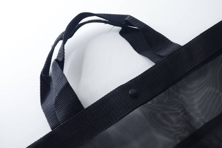 黒いトートバッグの持ち手と開閉用のスナップボタン