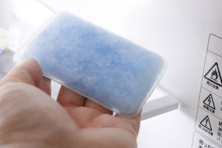 冷蔵庫の棚にスマホ冷却パッドを置いている様子