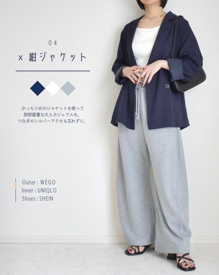 紺ジャケットと白インナー、グレーのスウェットパンツを着た女性