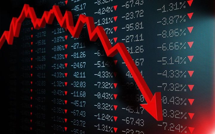 株価ボードの上で急落する赤い矢印のグラフ