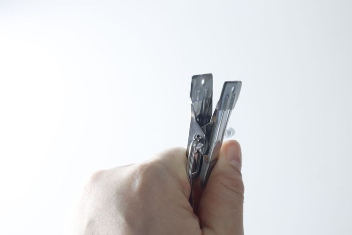 手でダイソーのフックピンチを握り、ピンチ部分を閉じている様子