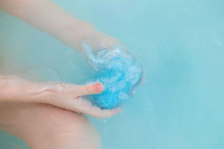 湯船で溶けていくバスボムを手にしている人