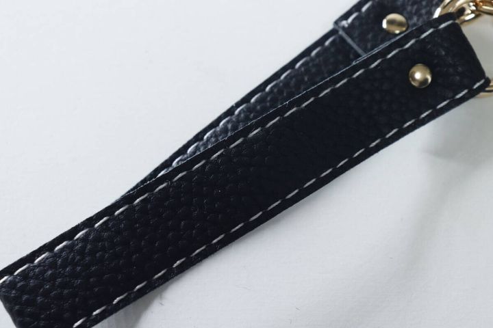 黒い合皮素材のスマホストラップのシボ感と白いステッチ