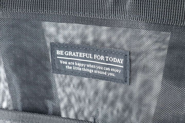 バッグの前面に縫い付けられた「BE GRATEFUL FOR TODAY」の英字ロゴ