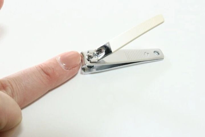 人差し指の爪を爪切りで切っている手元のクローズアップ