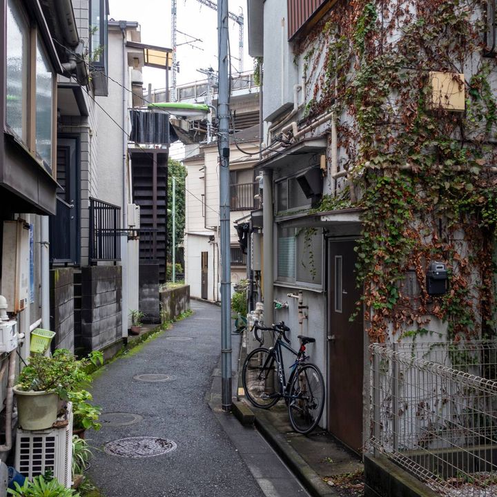 住宅に挟まれた、細く曲がる路地裏の風景