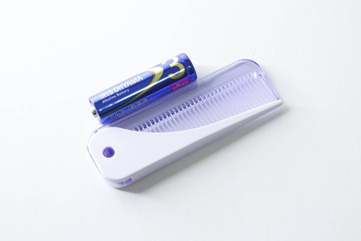 ダイソーの折りたたみコームと単三電池を並べて大きさを比較