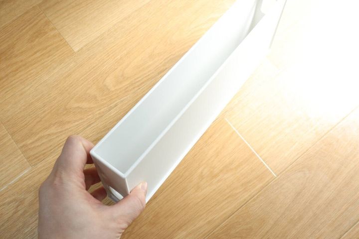 女性が白い極薄収納ボックスの片側を持っている様子
