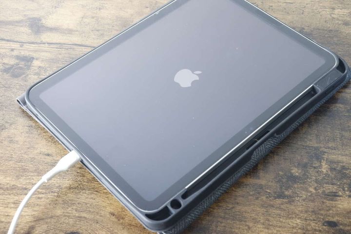 黒いケースに入ったiPadが白いケーブルでGaN USB充電器に接続され充電中