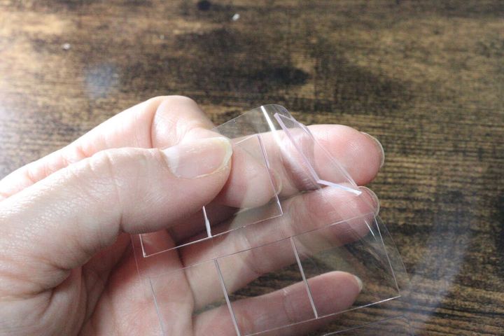 指で透明なゲルパッドシートの端を剥がしている様子