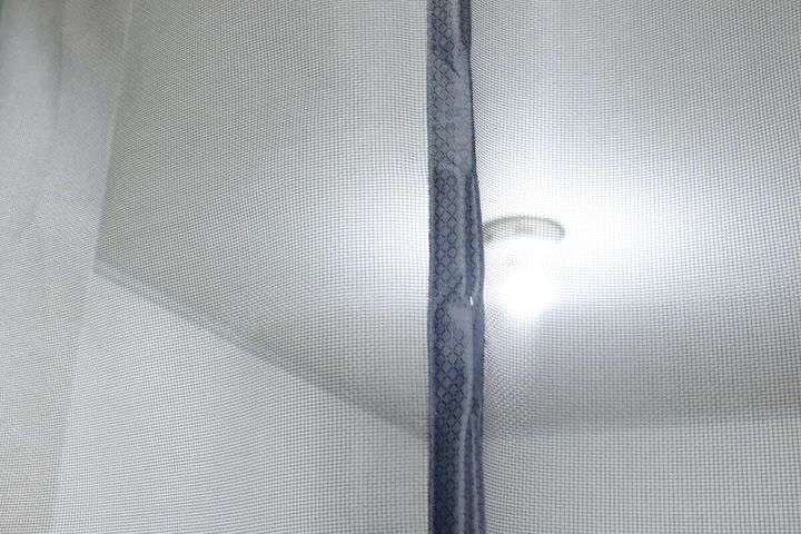 網戸越しに部屋の奥の照明が見える様子で、透過性がわかる