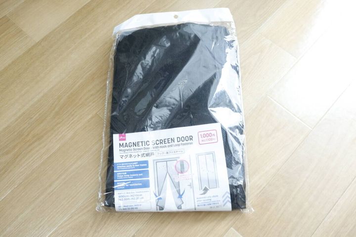 ダイソーのマグネット式網戸のパッケージが床に置かれている