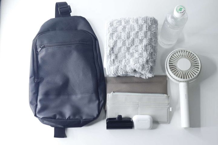 黒いバッグの隣に並べられたペットボトルやタオルなどの荷物
