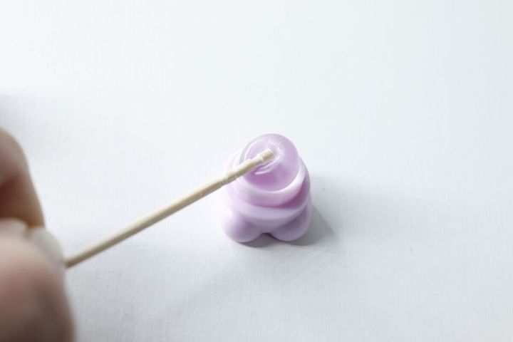 くまちゃん形のミニリップブラシのシリコーンブラシ部分を綿棒で拭いている様子