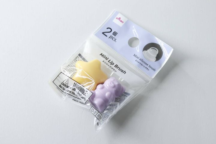 斜め上から見た、パッケージに入ったダイソーのミニリップブラシ。星形とくまちゃん形