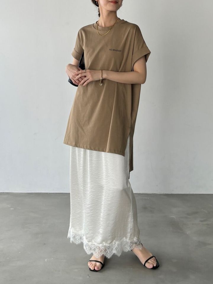 茶色のチュニックTシャツと白のレース裾ナロースカートを着用した女性の全身
