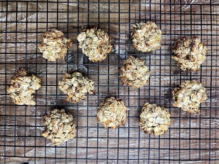 黒いケーキクーラーの上に、こんがりと焼き上がったオートミールクッキーが10個並べられている