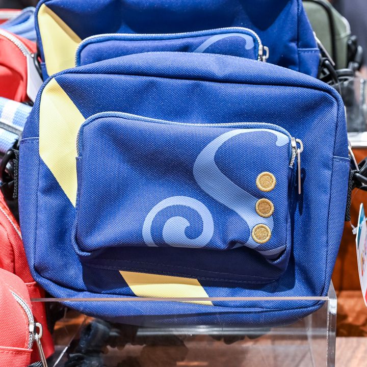 水色の渦巻き模様と金ボタンが並ぶ紺色のショルダーバッグ